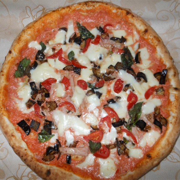 Pizza con salsa rosa, cotto, melanzane, fior di latte, pomodorini del Vesuvio