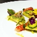 Raviolo di pasta cotta ripieno di ricotta e limone, salsa di zucchine, vongole, gambero rosso e briciole di pane - -