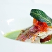 Filetto di triglia, panato in casseruola, su gazpacho di zucchine estive, aromatizzato con polvere d'arancio. - -